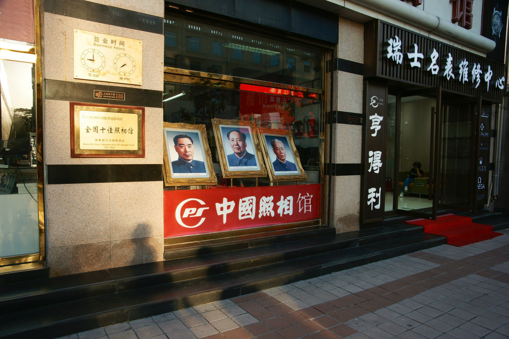 BEIJING, CHINA - SEP 17, 2017 : The photographs of Mao Zedong, Zhou Enlai and Liu Shaoqi at Wangfujing shopping area